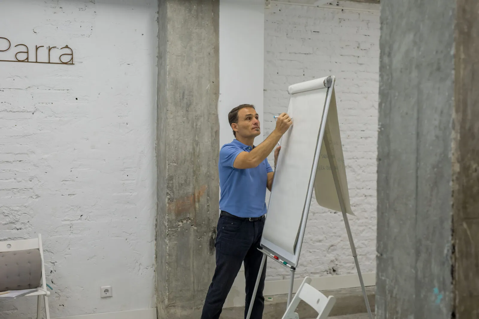 Diego Guerrero, trainer del Practitioner en PNL de Greatitute, escribiendo en un flipchart durante una formación