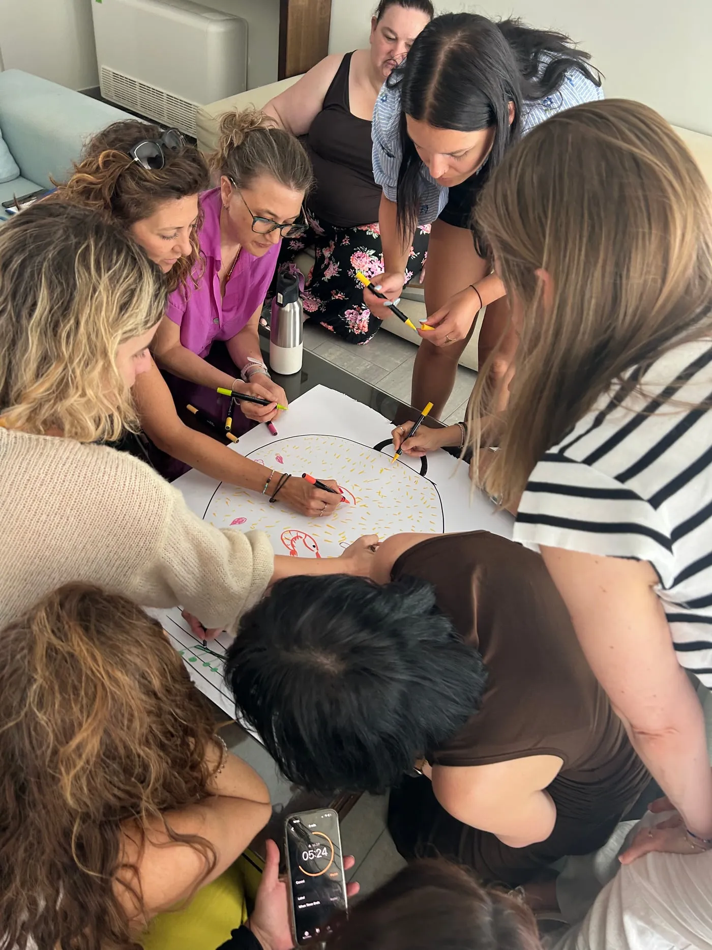 Participantes de una formación de Greatitute trabajando juntas sobre un papel